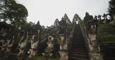 Pura Penataran Agung Lempuyang Tapınağı 'nda, Hindu tapınağındaki antik taş heykeller ve merdivenlerde çarpıcı ejderha kafası heykellerinin alçak açılı yakın çekim görüntüleri.