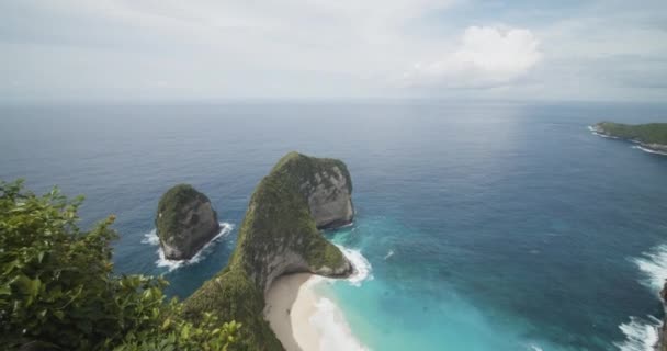 Dolly náklon odhalit záběr ohromující modré tropické pláže a poloostrova z vyhlídky Kelingking pláž a T-Rex Bay na Bali, Indonésie s tyrkysově modré vody a písečné pláže — Stock video