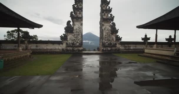 Tiltning dolly skott närmar sig på porten till himlen i Pura Penataran Agung Lempuyang tempel i Bali Berömd turistattraktion tempel grindar med Mount Agung vulkan i bakgrunden — Stockvideo