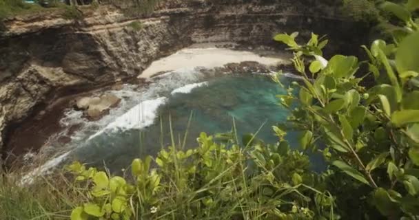 Camion dezvăluie fotografii de valuri prăbușindu-se pe țărmul plajei de nisip uimitoare cu mare albastră și stânci abrupte de ocean la Broken Beach Pasih Uug în Bali Indonezia — Videoclip de stoc