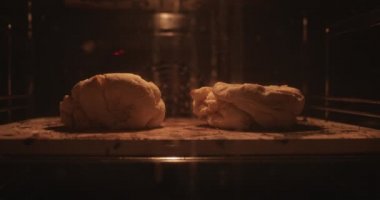 Fırından çıkan iki parça ev yapımı hamuru yakından izle. Sıcak fırında pişirilen el yapımı hamur görüntüsünü hızlandırır..