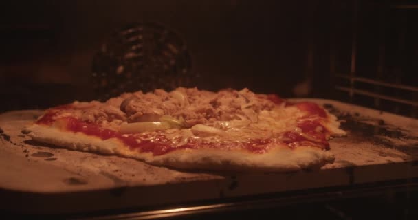 Versnel de video van een lekkere pizza met kaas, tonijn en uien in de oven. Thuis koken maakte heerlijke pizza met borrelende kaas. — Stockvideo