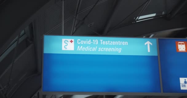 Blauw uithangbord richting medisch onderzoekscentrum voor COVID-testen. Routebeschrijving naar de testlocatie voor het coronavirus. — Stockvideo