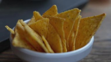 Beyaz kasedeki tortilla cipslerine yakından bak. Bulanık arkaplanlı parti atıştırmalıklarının izole görünümü