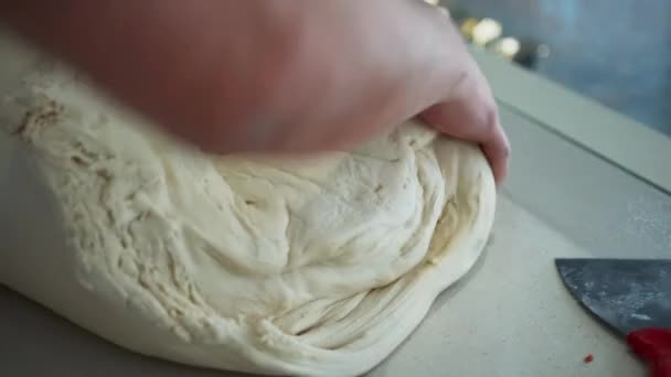 Baker büyük bir parça hamur yuvarlıyor ve ekmek yapıyor. Profesyonel fırıncı hamur işini pişirmeye hazırlıyor. — Stok video