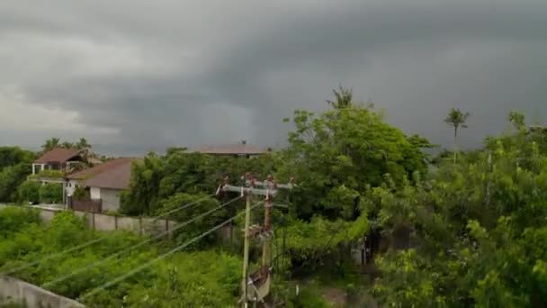 Ciemne chmury burzowe na tropikalnej plaży w Canggu, Bali podczas pory deszczowej. Widok z lotu ptaka na domy na plaży przed burzą w pustym kurorcie turystycznym — Wideo stockowe