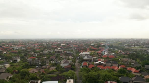Descendo vista aérea das ruas na cidade de Canggu, em Bali. Vista panorâmica ampla de casas residenciais e pequenas casas no famoso resort turístico em Bali tropical — Vídeo de Stock