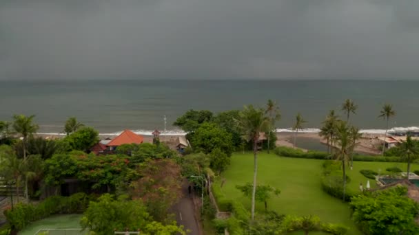 Schlechtes Wetter während der Regenzeit an einem tropischen Strand in Canggu, Bali. Luftaufnahme von Einheimischen auf den Straßen und am Strand vor dem Sturm in Touristenzielen in der Nebensaison — Stockvideo