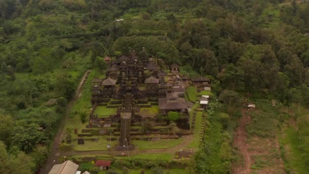 Antiguos edificios religiosos en el templo hindú Besakih en Bali, Indonesia. Vista aérea de impresionantes edificios antiguos del templo con pagodas altas rodeadas de selva tropical — Vídeos de Stock