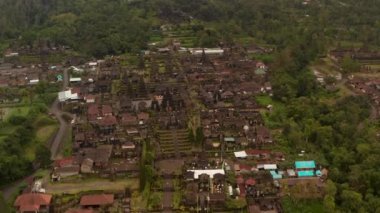 Endonezya, Bali 'deki Besakih Tapınağı' ndaki antik dini binaların havadan görünüşü. Turistlerin, uzun pagodalarla ünlü Hindu tapınağını keşfederken çekilen fotoğrafları.