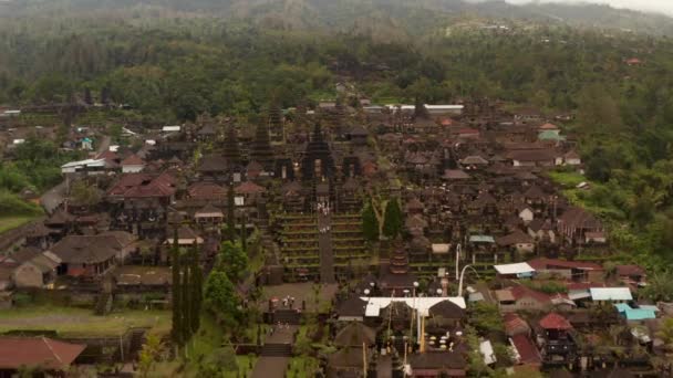 인도네시아 , 발리 의 베 사 키 사원을 탐험하는 관광객들에 대한 공중의 야비 한 광경. 유명 한 관광지에 있는 사람들이 유명 한 힌두 신전의 종교 건물들과 건축물들을 구경하는 모습 — 비디오