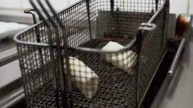 Restoranın mutfağında kızartmalı börek. Taze börekleri pişirme yağına bandırıyorum.