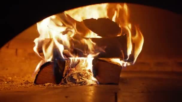 Close-up zicht op houtblokken die branden in een bakstenen oven. Warm gezellig haardvuur in restaurant oven — Stockvideo
