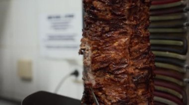 Donör kebabı için elektrikli testereyle et kesmek. Geleneksel Balkan yemeğinin hazırlanmasına yakın görüş