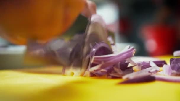 Vista de cerca de un cuchillo cortando cebolla roja en rodajas finas. Vista de cerca de un cocinero cortando rápidamente una verdura morada — Vídeos de Stock