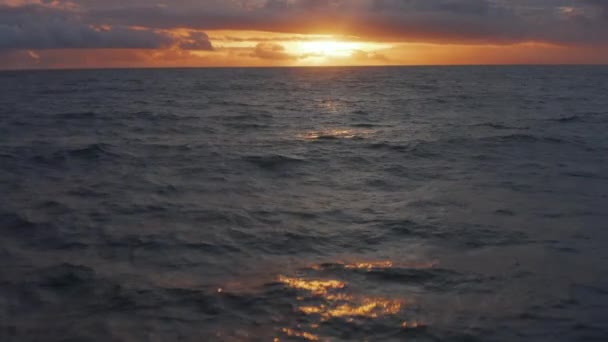 Okyanusta altın gün batımının alacakaranlık görüntüsü. Derin mavi denizde güzel turuncu gün batımının havadan çekimleri. — Stok video