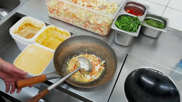 Trabajador de restaurantes de comida rápida mezclando varias verduras en un wok. Verduras mixtas en platos asiáticos tradicionales — Vídeos de Stock