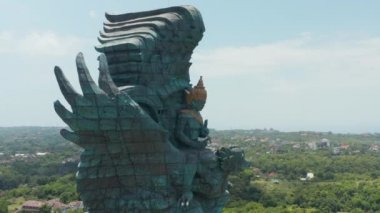 Endonezya, Bali 'deki dev Garuda Wisnu Kencana heykelinin yan doli görüntüsü. Vishnu 'nun bindiği Garuda heykeli şehrin üzerinde yükseliyor.