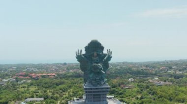 Endonezya 'nın Bali kentindeki kültür parkında Garuda Wisnu Kencana' nın dev bakır heykeli. Havadan çekilen kule şehrin üzerinde yükselen büyük dini heykel görüntüsü