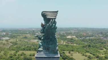 Endonezya, Bali 'deki büyük bakır heykelin yan görüntüsü. Garuda Wisnu Kencana heykeli şehrin üzerinde yükseliyor.