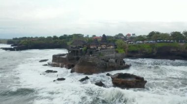 Bali, Endonezya 'daki fırtına sırasında boş Tanah Lot tapınağının hava dönüşümlü çekimi. Güçlü deniz dalgaları ünlü turizm merkezli kayalık kayalıklara çarpıyor.