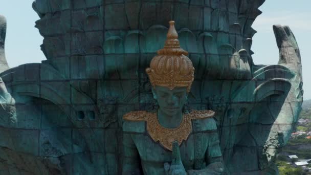 Blisko widok Garuda Wisnu Kencana statua w parku w Bali, Indonezja, wznoszące się nad miastem. Antena wycofuje się ujawnić duży niebieski i zielony posąg religii hinduskiej — Wideo stockowe