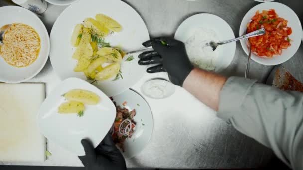 Trabalhador de fast food que serve batatas e arroz no prato. Visão aérea de cima para baixo do trabalhador de restaurante que prepara o prato de várias chapas em uma chapa — Vídeo de Stock