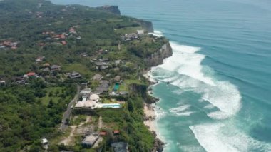 Lüks tropikal villalar ve Endonezya 'nın Bali kentindeki turkuaz mavi denizin üzerindeki uçurumun tepesinde havuzları olan tatil evleri.