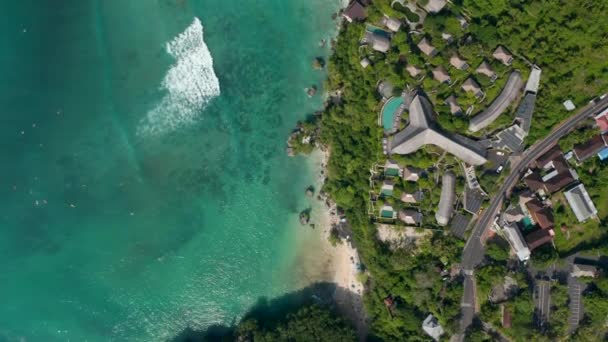 Πολυτελή τροπικά θέρετρα και βίλες στο βράχο πάνω από τροπικό γαλάζιο ωκεανό στο Μπαλί, Ινδονησία. Αεροφωτογραφία από πάνω προς τα κάτω τα γενικά των ακριβών σπιτιών στις ακτές του Μπαλί — Αρχείο Βίντεο