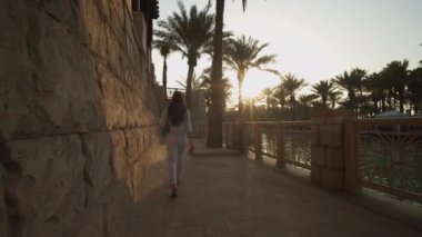 Dubai 'de lüks bir mahallede nehir kenarında bir kadını takip etmek. Birleşik Arap Emirlikleri 'nin yerleşim yerlerindeki lüks yaşam tarzı