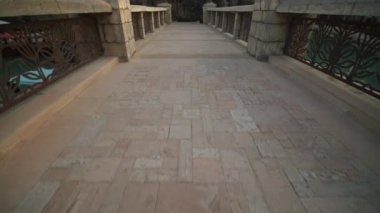 Dubai 'deki lüks oteldeki su kanalı üzerinde taş köprü. Lüks tropikal tatil beldesindeki palmiye ağaçlarıyla çevrili taş köprü manzarası.