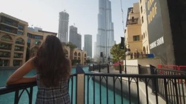Dubai 'deki balkondan Burj Halife' nin gökdelenini izleyen bir kadın. Dubai 'deki lüks apartmanda havuz kenarında dinlenen bir turist.