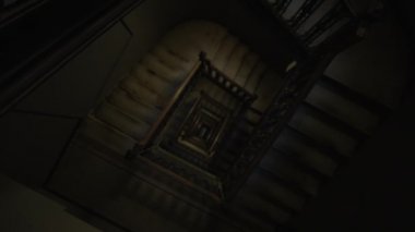 Karanlığa giden eski ahşap merdivenlerin yukarıdan görünüşü. Tarihi binada eski kırsal merdiven boşluğu