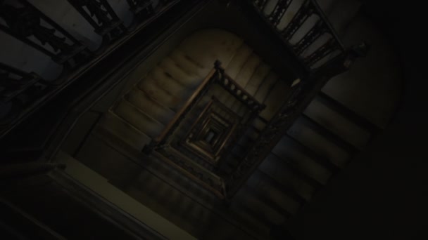 Спускающийся сверху вид старой деревянной лестницы, ведущей в темноте — стоковое видео