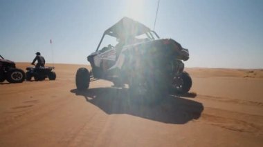 Çöldeki kum tepelerinde hızlı kum arabası sürüyordu. Dubai yakınlarındaki çölde güneşli bir günde açık hava motorsporları aktiviteleri