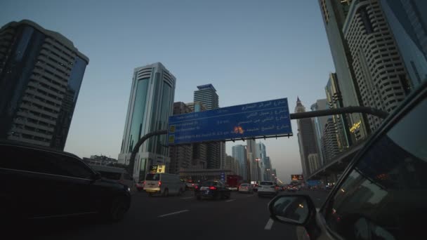 晚上在迪拜的一条多车道公路上开车。迪拜市中心被高耸的摩天大楼环绕的街道第一眼看到的汽车驾驶情况 — 图库视频影像