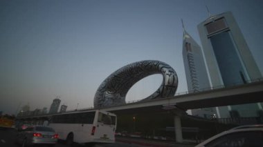 Dubai 'deki Geleceğin Müzesi heykelinin yanından geçiyoruz. Dubai şehir merkezinde müzenin önündeki fütüristik metal heykel