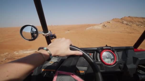 Вид от первого лица на вождение багги с песком в пустыне. Женщина водит внедорожник по песчаным дюнам — стоковое видео