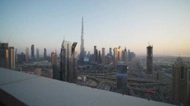 Gün batımında Dubai 'nin şehir merkezindeki modern cam gökdelenler. Burç Halife ve yoğun şehir trafiği Dubai 'de bir otoyolda