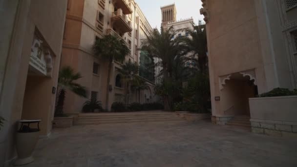 Gatuvy över lyxigt lägenhetskomplex i Dubai. Rikt bostadsområde med palmer i Förenade Arabemiraten — Stockvideo