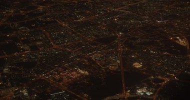 Bir uçak penceresinden gece şehir ışıklarının görüntüsü