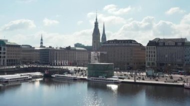 Binnenalster Gölü kıyısındaki insanların hava görüntüsü ve Hamburg belediye binası arka planda.
