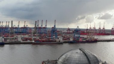 Hamburg limanında konteynırlı pek çok kargo gemisi ve vincin havadan görüntüsü