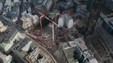 Hamburg şehir merkezindeki St. Nikolai Dünya Savaşı Anıtı kalıntıları yakınlarındaki vinç ve inşaat malzemelerinin havadan görüntüsü alçalıyor.