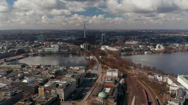 Wide aerial view of car and train traffic across Binnenalster lake with Hamburg panorama in the background — Stock Video