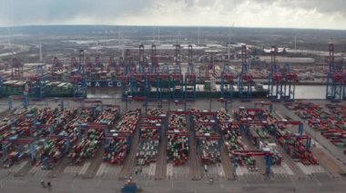 Almanya 'nın Hamburg kentindeki endüstriyel limanda renkli konteynırların ve büyük kargo vinçlerinin hava kulesi görüntüsü