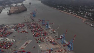 Hamburg, Almanya 'da nehir kıyısında renkli kargo konteynerleri olan büyük ticari kargo limanı.