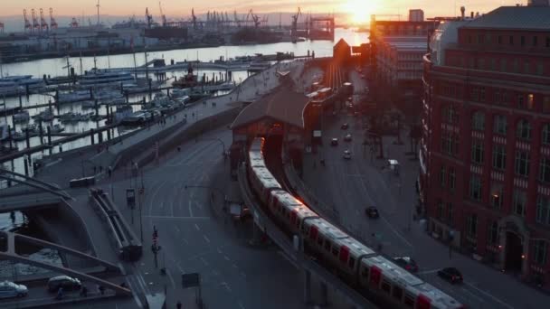 Comboio que sai da estação perto do porto de Hamburgo junto ao rio Elba durante o pôr-do-sol — Vídeo de Stock