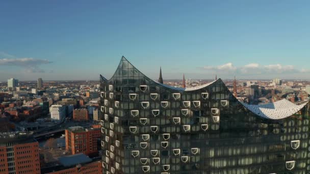 Gros plan vue aérienne de la salle de concert moderne Elbphilharmonie sur le toit avec révélation de célèbres églises de Hambourg en arrière-plan — Video