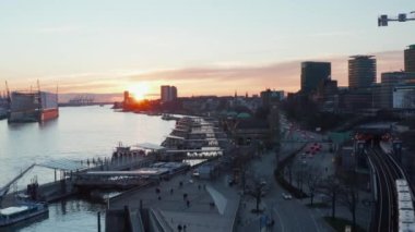 Gün batımında Hamburg şehir merkezinde Elbe nehrinin kıyısında trafik ve yaşam tarzı